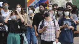 Orang-orang yang memakai masker untuk membantu melindungi diri dari penyebaran virus corona berdiri di persimpangan di Tokyo, Senin (30/8/2021). Kementerian Kesehatan Jepang tengah menginvestigasi kematian dua orang yang menerima vaksin COVID-19 Moderna pada Agustus lalu. (AP Photo/Koji Sasahara)