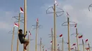 Pekerja memasang bendera Merah Putih pada pohon pinang untuk acara panjat pinang kolosal di kawasan Ancol, Jakarta, Kamis (15/8/2019). Ancol Taman Impian memasang sebanyak 174 batang pohon pinang untuk meriahkan Hari Kemerdekaan dengan tema " Pesta Manusia Merdeka". (Liputan6.com/Herman Zakharia)