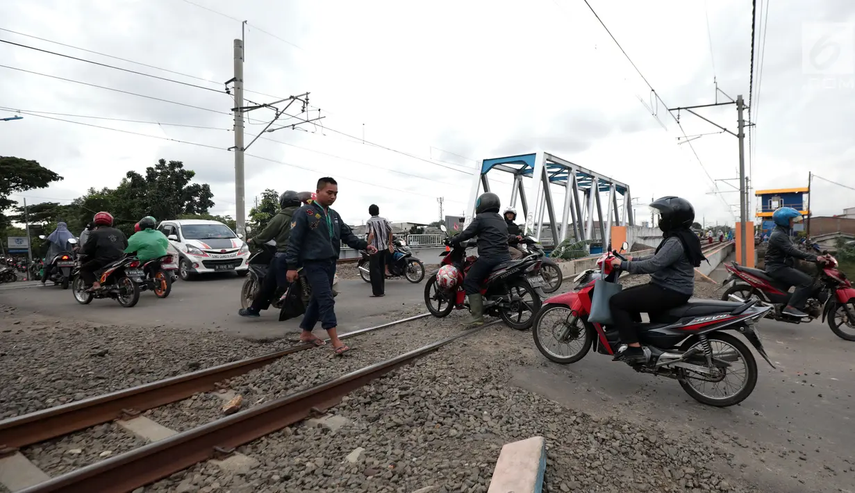 Pengendara motor melewati perlintasan kereta api tanpa palang pintu di kawasan Kelingkit, Rawa Buaya, Jakarta, Selasa (26/2). Rel kereta tanpa adanya palang pintu penutup ini sangat berbahaya karena bisa menyebabkan kecelakaan. (Liputan6.com/Johan Tallo)