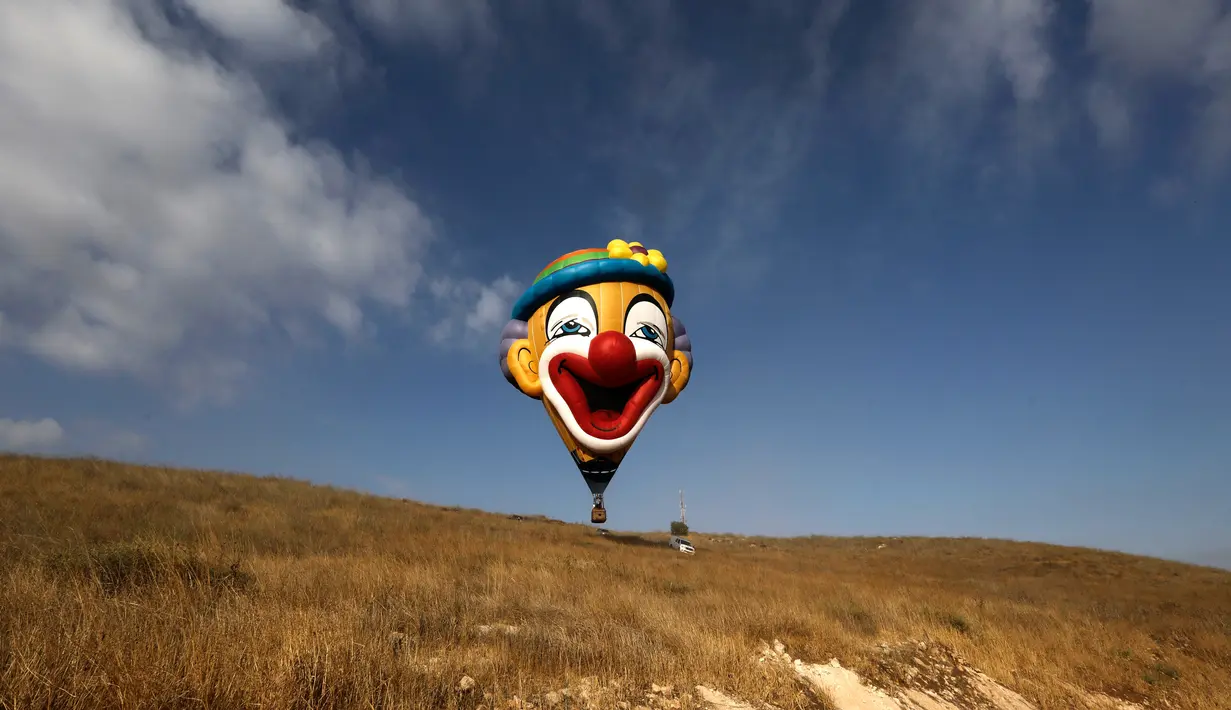 Balon udara berkarakter badut bersiap mengudara saat Festival Balon Udara Gilboa di dekat Kibbutz Ein Harod, Lembah Jizreel, Israel (4/8). (AFP Photo/Manahem Kahana)