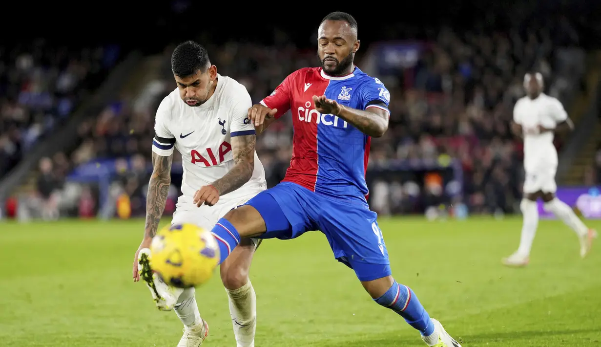 Pemain Tottenham Hotspur, Christian Romero, berebut bola dengan pemain Crystal Palace, Jordan Ayew, pada laga Liga Inggris di Stadion Selhurst Park Sabtu (28/10/2023). (PA/Via AP/(John Walton)