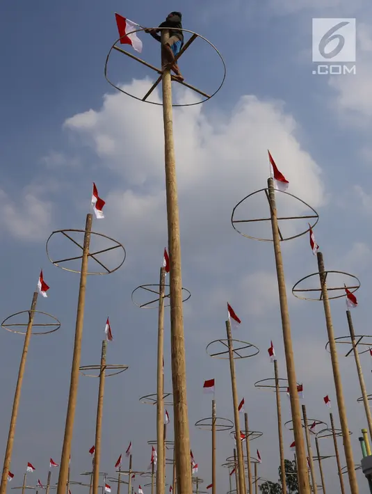 Pekerja memasang bendera Merah Putih pada pohon pinang untuk acara panjat pinang kolosal di kawasan Ancol, Jakarta, Kamis (15/8/2019). Ancol Taman Impian memasang sebanyak 174 batang pohon pinang untuk meriahkan Hari Kemerdekaan dengan tema " Pesta Manusia Merdeka". (Liputan6.com/Herman Zakharia)