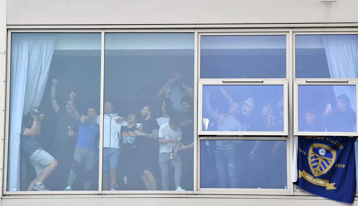 Pemain Leeds United melihat perayaan suporter dari jendela stadion Elland Road, Leeds, Sabtu (18/7/2020). Leeds United dipastikan promosi ke Premier League musim 2020/2021 usai West Brom kalah 1-2 atas Huddersfield Town. (AFP/Paul Ellis)