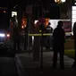 Petugas polisi berdiri di luar gedung bisnis tempat penembakan terjadi di Orange, California California (31/3/2021).  Tersangka ditahan dan juga dibawa ke rumah sakit. (AP Photo/Jae C. Hong)