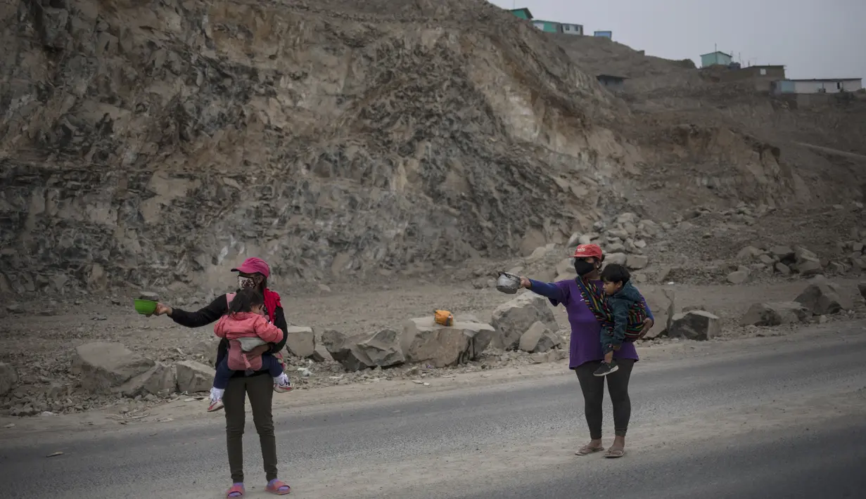 Pilar Gonzalez dan Jenny Diaz sambil menggendong anak mengemis selama pandemi virus corona di Lima, Peru (22/8/2020).  Peru diketahui menganggarkan dana sebesar 400 juta dolar AS atau Rp 5,8 triliun (kurs Rp 14.500/US$) untuk memberi makan 12 juta warga miskin selama satu bulan. (AP Photo/Rodrigo Ab