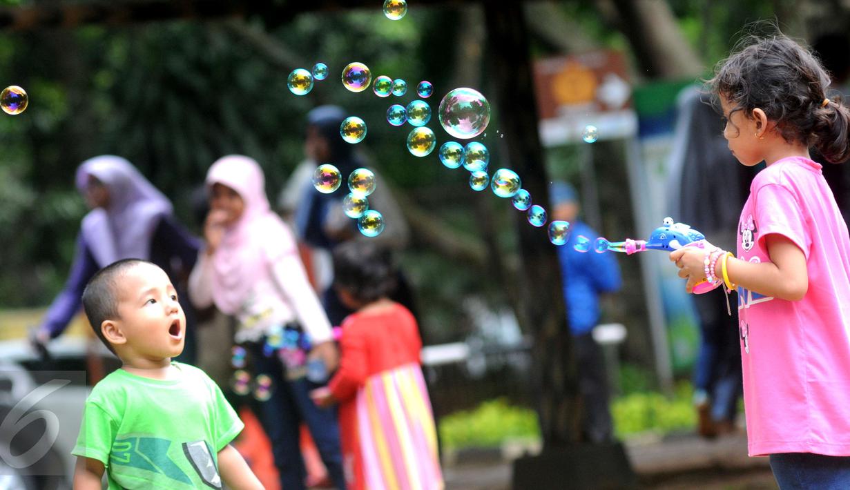 Anak-anak bermain gelembung saat berkunjung ke Ragunan, Jakarta, Minggu (25/12). Ragunan masih menjadi tempat favorit warga untuk mengisi libur panjang. (Liputan6.com/Helmi Afandi)