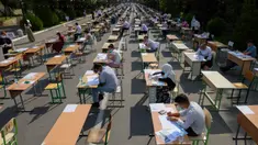 Para siswa Uzbekistan mengikuti ujian masuk luar ruangan, di tengah pandemi COVID-19 yang sedang melanda, di Tashkent pada Rabu (2/9/2020). (Photo by Yuri KORSUNTSEV / AFP)