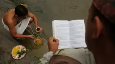 Umat Hindu Nepal melakukan ritual pemujaan dengan bantuan pemuka agama saat festival Kuse Aunsi di kuil Hindu Gokarneshwar di Kathmandu, Nepal (21/8). Kushe Aunsi merupakan bentuk perayaan Hari Ayah bagi masyarakat Nepal. (Niranjan Shrestha/AP) 