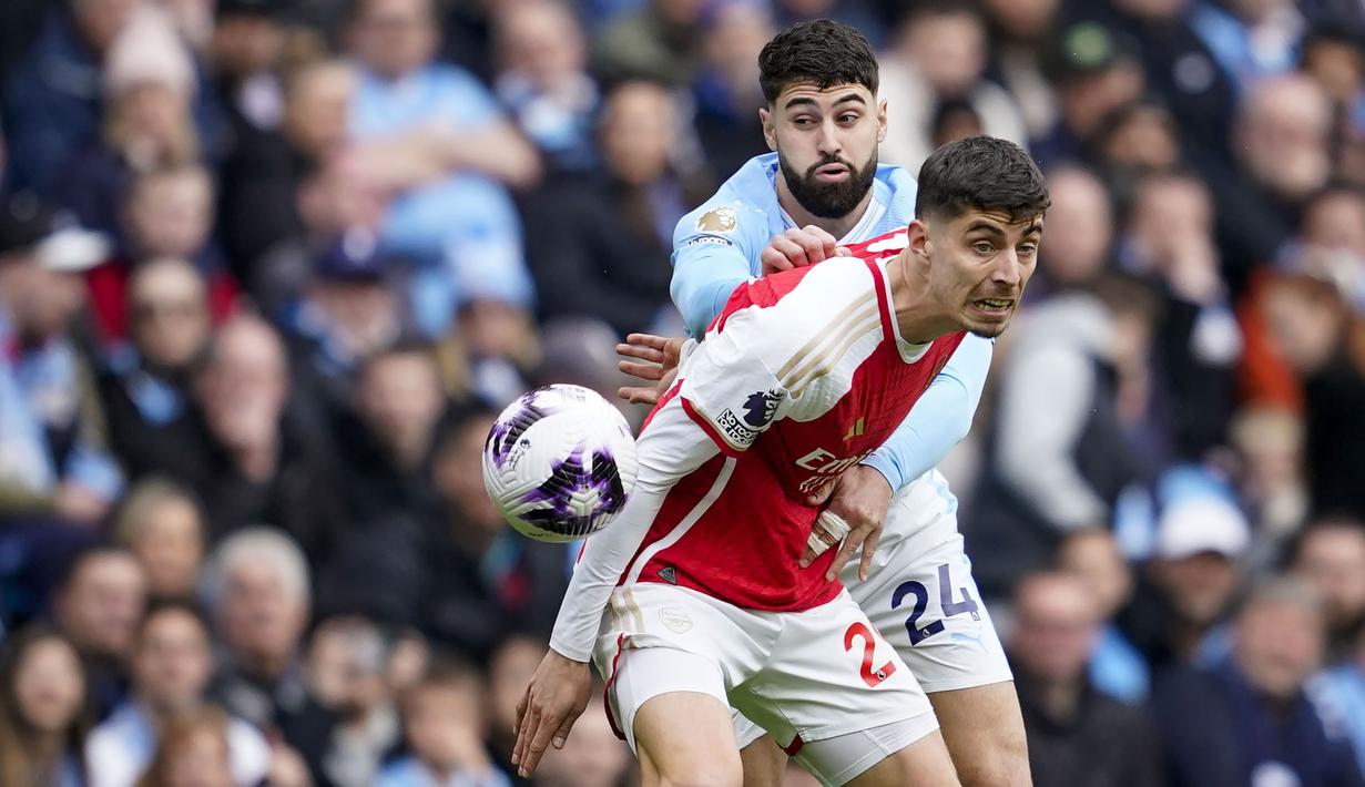 Gelandang Arsenal, Kai Havertz (depan) berebut bola dengan bek Manchester City, Josko Gvardiol pada laga pekan ke-30 Premier League 2023/2024 di Etihad Stadium, Manchester, Minggu (31/3/2024). (AP Photo/Dave Thompson)