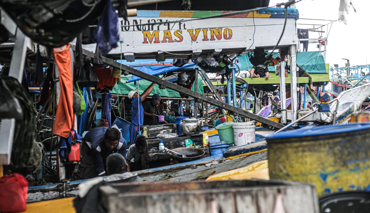 Nelayan beraktivitas di perahu saat bersandar di Pelabuhan Muara Angke, Jakarta, Senin (26/12/2022). Akibat angin  barat dan gelombang tinggi menyebabkan nelayan tradisional di Muara Angke libur melaut. (Liputan6.com/Faizal Fanani)