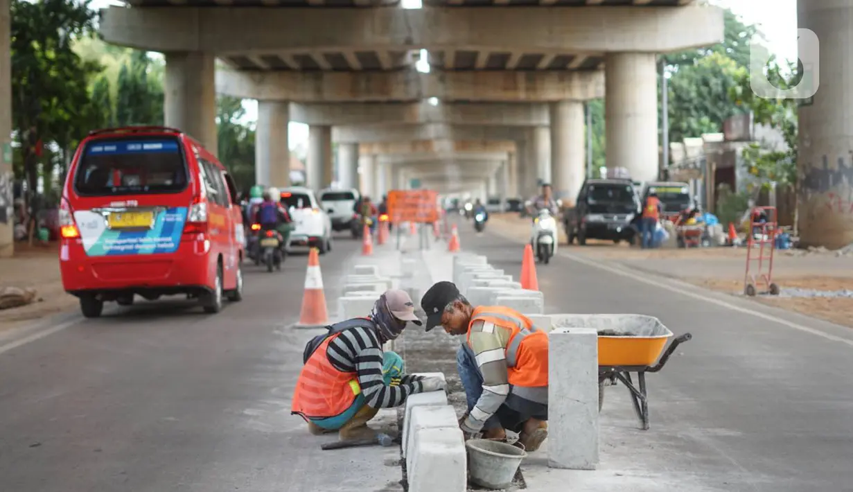 Pekerja menyelesaikan pembuatan separator atau pembatas jalan di Jalan Margasatwa, Andara, Jakarta Selatan, Kamis (21/11/2019). Separator itu dibuat guna memisahkan dua lajur sehingga meminimalisasi tingkat kecelakaan. (Liputan6.com/Immanuel Antonius)