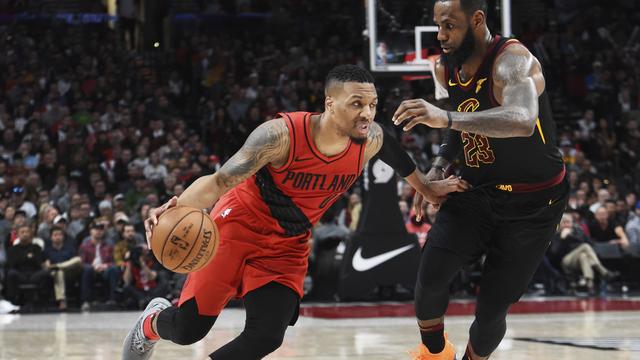 Damian Lillard (merah) berduel dengan LeBron James