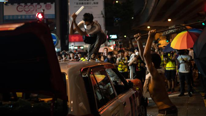 Demonstran menghancurkan sebuah taksi di Hong Kong, Minggu (29/9/2019). Demonstran di Hong Kong mengaku semakin bersemangat walau aparat melakukan tindak kekerasan. (AP Photo/Felipe Dana)