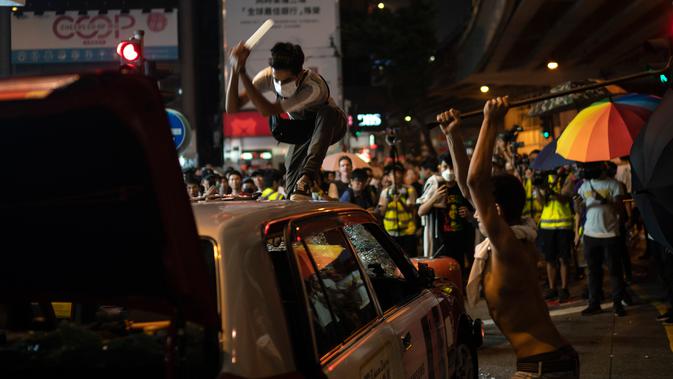 Demonstran menghancurkan sebuah taksi di Hong Kong, Minggu (29/9/2019). Demonstran di Hong Kong mengaku semakin bersemangat walau aparat melakukan tindak kekerasan. (AP Photo/Felipe Dana)