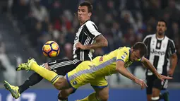 Striker Juventus, Mario Mandzukic, berebut bola dengan bek Pescara, Hugo Campagnaro. Gol pertama Si Nyonya Tua terjadi pada menit ke-36 melalui Semi Khedira. (AFP/Marco Bertorello)