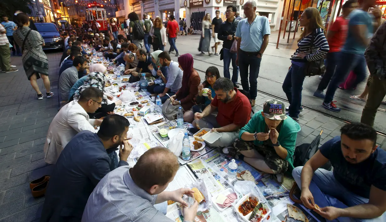 Sejumlah orang mempersiapkan diri untuk berbuka puasa pada hari pertama bulan suci Ramadan, di dekat Taksim Square, Istanbul, Turki, Kamis (18/6/2015). (REUTERS/Osman Orsal)