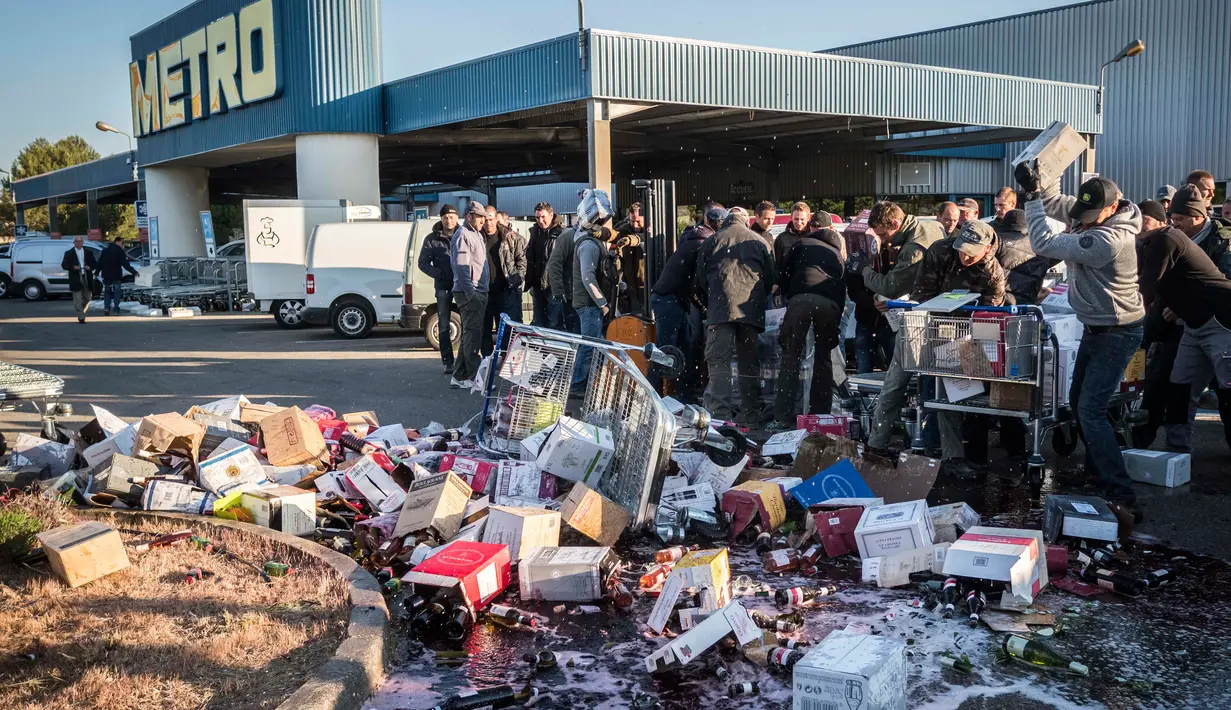Minuman anggur ditumpahkan saat aksi protes di sebuah hypermarket di Nimes, Perancis, Kamis (20/4). Pedagang minuman Perancis marah karena harga minuman anggur dari Spanyol terlampau murah. (AP Photo / Arnold Jerocki)