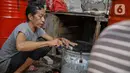 Pekerja menyelesaikan pembuatan bedug di jalan KH Mas Mansyur, Tanah Abang, Jakarta, Senin (10/6/2021). Menjelang Idul Fitri 1442 H, pedagang bedug di sepanjang jalan itu mulai ramai menjajakan dagangannya dari harga 40 ribu hingga Rp 2,5 juta. (Liputan6.com/Faizal Fanani)