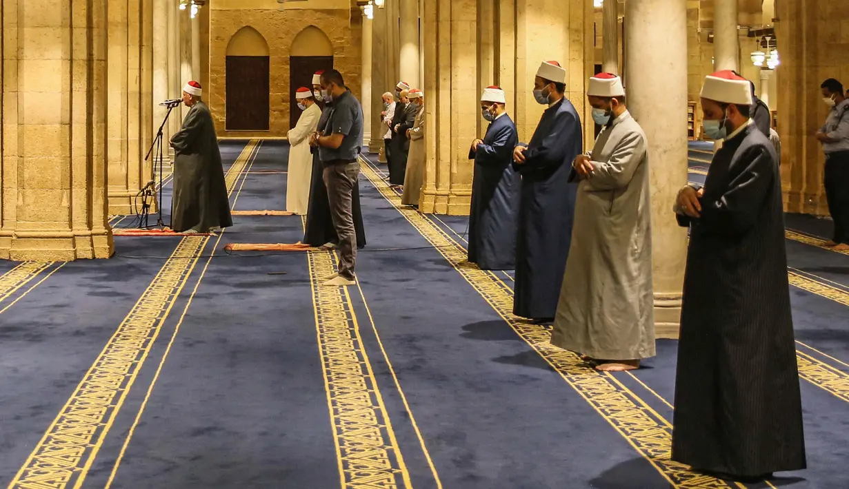 Umat Muslim melaksanakan salat tarawih dengan menerapkan jaga jarak selama bulan Ramadan di Masjid al-Azhar, Kairo, Minggu (17/5/2020). Bagi umat Islam di seluruh dunia menjalankan ibadah puasa tahun ini di tengah pembatasan akibat corona Covid-19 adalah yang pertama kalinya. (Samer ABDALLAH/AFP)