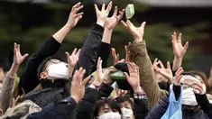 Orang-orang mencoba menangkap kacang keberuntungan yang disebarkan selama "Mame-maki", upacara melempar kacang, di kuil Buddha Zojoji, Tokyo, Jumat (3/2/2023). Ritual yang diyakini membawa keberuntungan dan mengusir kejahatan ini dilakukan setiap tahun untuk menandai awal musim semi dalam kalender lunar. (AP Photo/Eugene Hoshiko)