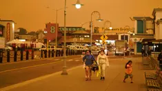 Sejumlah orang berjalan saat kabut asap menyelimuti langit di Fisherman's Wharf, San Francisco, Amerika Serikat, Rabu (9/9/2020). Kebakaran hutan di seluruh Barat mengakibatkan langit San Francisco hingga Seattle berwarna oranye yang menakutkan. (AP Photo/Eric Risberg)