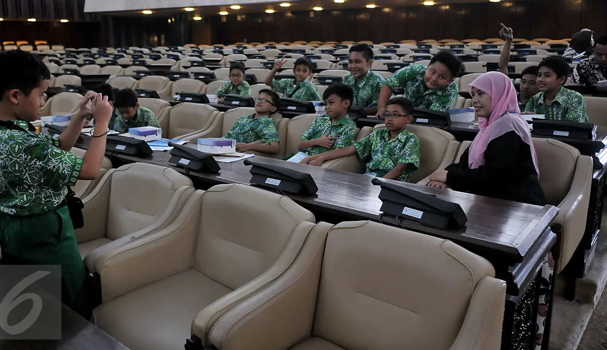 Siswa SD Al-Azhar Kebayoran Lama dan seorang guru berfoto bersama saat kunjungan ke kompleks Parlemen, Jakarta, Kamis (5/11/2015). Kunjungan ke Gedung DPR dalam rangka study tour dan pemahaman materi pelajaran tentang trias politica (Liputan6/Johan Tallo)