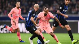 Gelandang Barcelona, Arturo Vidal, berusaha melewati gelandang Inter Milan, Matias Vecino, pada laga Liga Champions di Stadion San Siro, Milan, Selasa (6/11). Kedua klub bermain imbang 1-1. (AFP/Marco Bertorello)