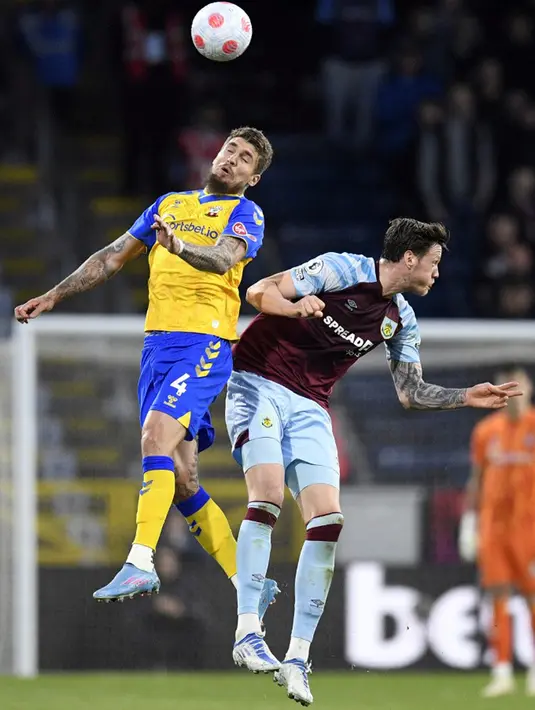 <p>Pemain Southampton Lyanco (kiri) berebut bola udara dengan pemain Burnley Wout Weghorst (kanan) pada pertandingan Liga Inggris di Turf Moor, Burnley, Inggris, 21 April 2022. Burnley menang 2-0. (Oli SCARFF/AFP)</p>