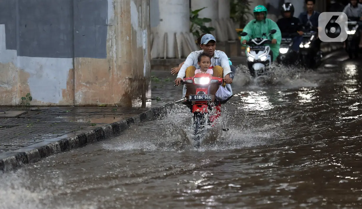 Akibat banjir tersebut membuat arus lalu lintas dan akivitas warga terhambat saat melintasi jalan. (Liputan6.com/Johan Tallo)