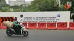 Pengendara sepeda motor melintas dekat proyek pembangunan jalur kereta Light Rail Transit (LRT) di Jalan Setiabudi Tengah, Jakarta, Senin (17/6/2019). Jalan Setiabudi Tengah ditutup mulai 17 Juni 2019 hingga 20 Februari 2020. (Liputan6.com/Herman Zakharia)