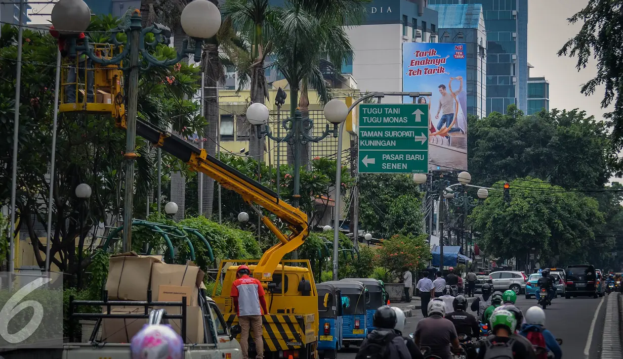 Sebuah mobil crane digunakan untuk membantu petugas memperbaiki lampu jalan di Kawasan KH Wahid Hasyim, Jakarta, Selasa (27/9). Perawatan rutin dilakukan untuk memastikan penerangan untuk jalan dan patung tetap berfungsi. (Liputan6.com/Faizal Fanani)