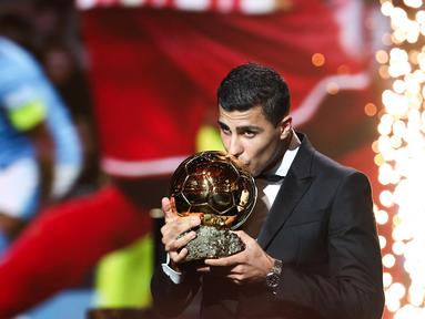 Gelandang Manchester City asal Spanyol, Rodri mencium trofi saat menerima penghargaan Ballon d'Or dalam acara penganugerahan Ballon d'Or France Football 2024 di Theatre du Chatelet, Paris, 28 Oktober 2024. (FRANCK FIFE/AFP)