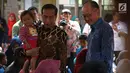 Presiden Joko Widodo (Jokowi) menggendong balita sambil mengajak Presiden Bank Dunia Jim Yong Kim blusukan ke Desa Tangkil, Kecamatan Caring, Bogor, Rabu (4/7). Keduanya meninjau Posyandu dan PAUD di dekat SDN 01 Tangkil. (Liputan6.com/Angga Yuniar)