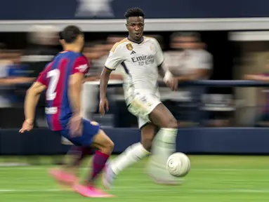 Pemain depan Real Madrid Vinicius Jose Paixao (kanan) mencoba menggiring bola melewati bek FC Barcelona Sergino Dest dalam laga pramusim bertajuk Soccer Champions Tour di AT&T Stadium, Texas, Amerika Serikat, Minggu (30/7/2023) dini hari WIB. (AP Photo/Jeffrey McWhorter)