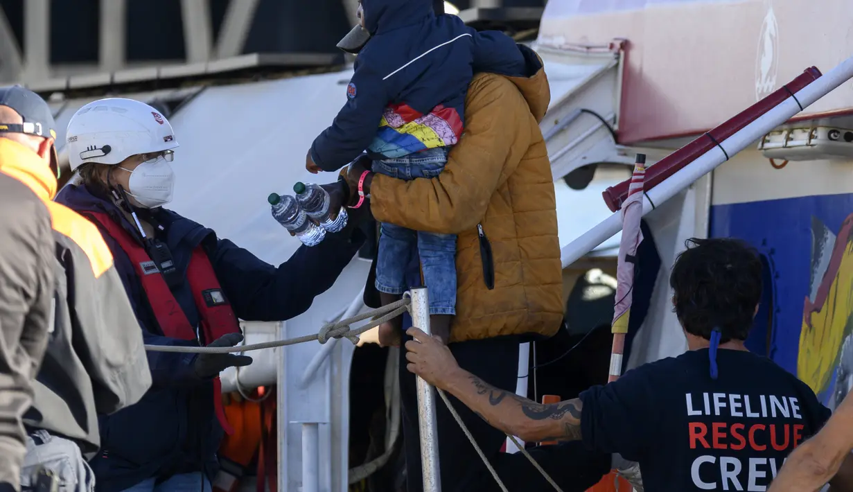 Para migran turun dari kapal kemanusiaan Jerman Rise Above berlabuh di kota pelabuhan Italia selatan Reggio Calabria, Selasa (8/11/2022). Kelompok kemanusiaan Jerman Mission Lifeline mengatakan kapalnya berlabuh di Italia selatan Selasa pagi dan menurunkan 89 orang yang telah diselamatkannya di Mediterania tengah. (AP Photo/Valeria Ferraro)