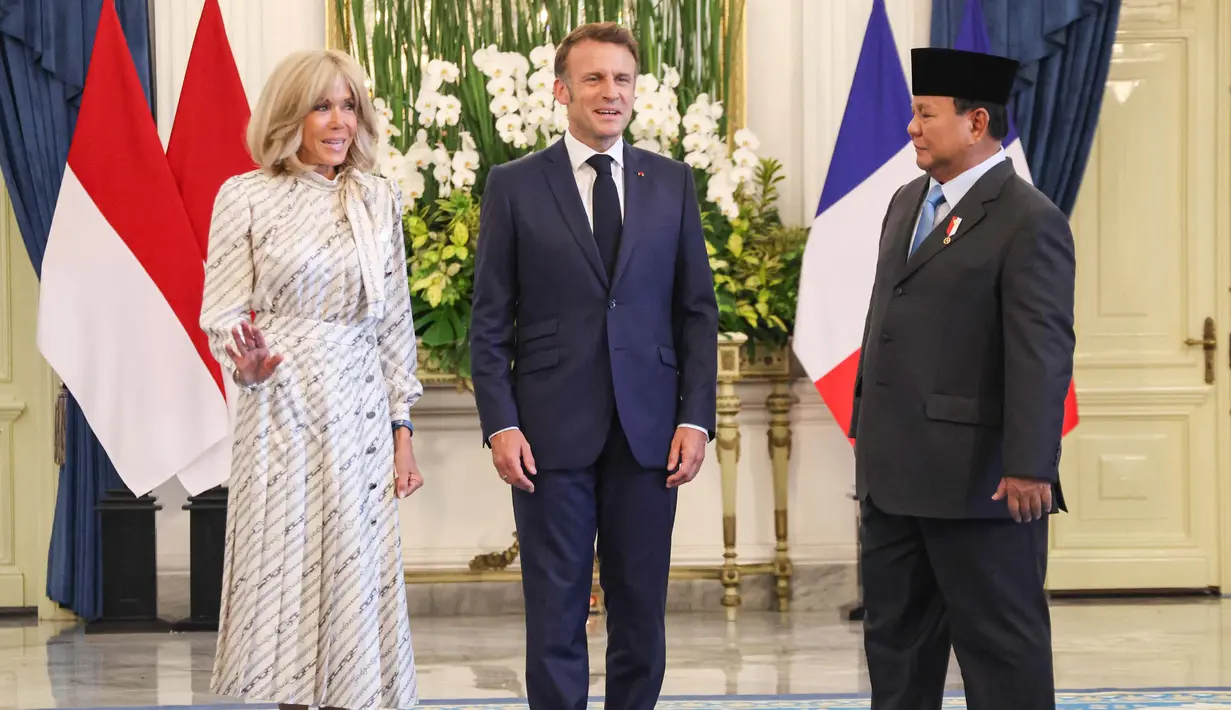 Setelah menandatangani buku tamu, Presiden Prancis Emmanuel Macron dan istrinya Brigitte Macron berfoto bersama Presiden Prabowo Subianto. (Ludovic MARIN/AFP)