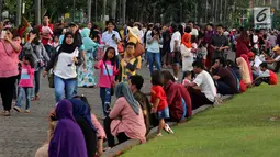 Pengunjung memadati kawasan Monumen Nasional (Monas), Jakarta, Rabu (27/6). Mengisi waktu libur Idul Fitri, kawasan Monas menjadi pilihan alternatif untuk berlibur bersama sanak keluarga. (Liputan6.com/Johan Tallo)