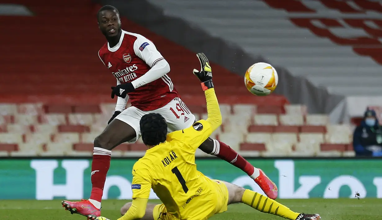 Gelandang Arsenal, Nicolas Pepe melepaskan tendangan yang berbuah gol ke gawang Slavia Praha dalam laga leg pertama perempatfinal Liga Europa 2020/2021 di Emirates Stadium, London, Kamis (8/4/2021). Arsenal bermain imbang 1-1 dengan Slavia Praha. (AFP/Ian Kington)