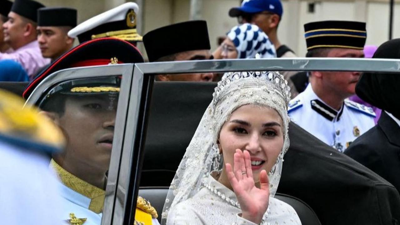 Pangeran Abdul Mateen bersama Yang Mulia Anisha Rosnah melambaikan tangan kepada masyarakat.<br>( Foto MOHD RASFAN / AFP )<br>