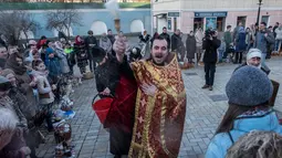 Imam Ortodoks Ukraina mencipratkan air saat memberkati jemaatnya dalam perayaan Paskah di Biara Volodymyrskiy di Kiev, Ukraina (8/4). Mereka melakukan Paskah sesuai kalender Julian kuno. (AP Photo / Evgeniy Maloletka)