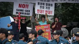 Sejumlah wanita menggelar aksi anti-gay saat acara parade 'Gay Pride' di Seoul, Korea Selatan (15/7). Mereka adalah warga religius di Korea Selatan yang telah lama menerapkan sikap keras terhadap parade gay tahunan tersebut. (AFP Photo/Ed Jones)