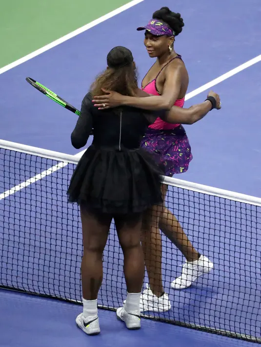 Petenis Serena Williams (kiri) memeluk kakak perempuannya, Venus Williams usai bertanding di putaran ketiga turnamen tenis AS Terbuka di New York, Jumat (31/8). Serena mengalahkan Venus dengan skor 6-1, 6-2. (AP Photo/Julio Cortez)