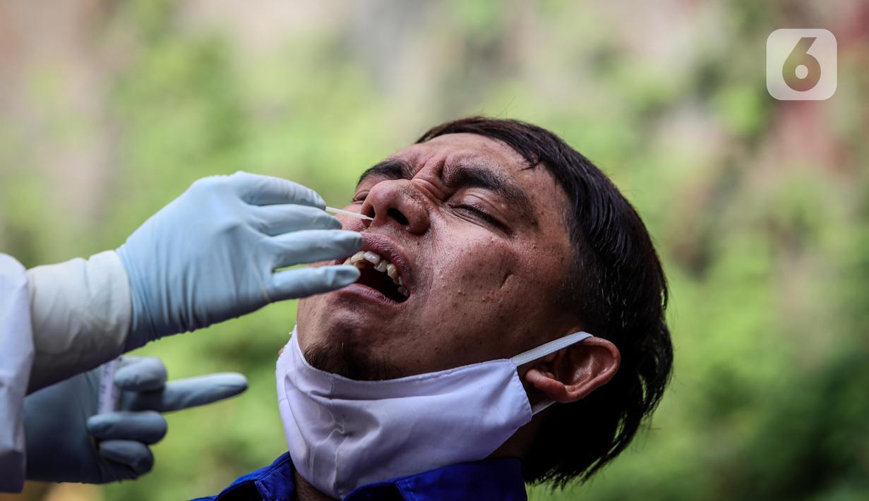 Warga diambil sampelnya saat mengikuti swab test COVID-19 di Pasar Tasik, Jakarta, Kamis (2/7/2020). Tes yang dilakukan secara acak bagi pedagang itu bertujuan untuk mendeteksi serta mencegah penyebaran COVID-19 di kawasan Pasar Tasik. (Liputan6.com/Faizal Fanani)