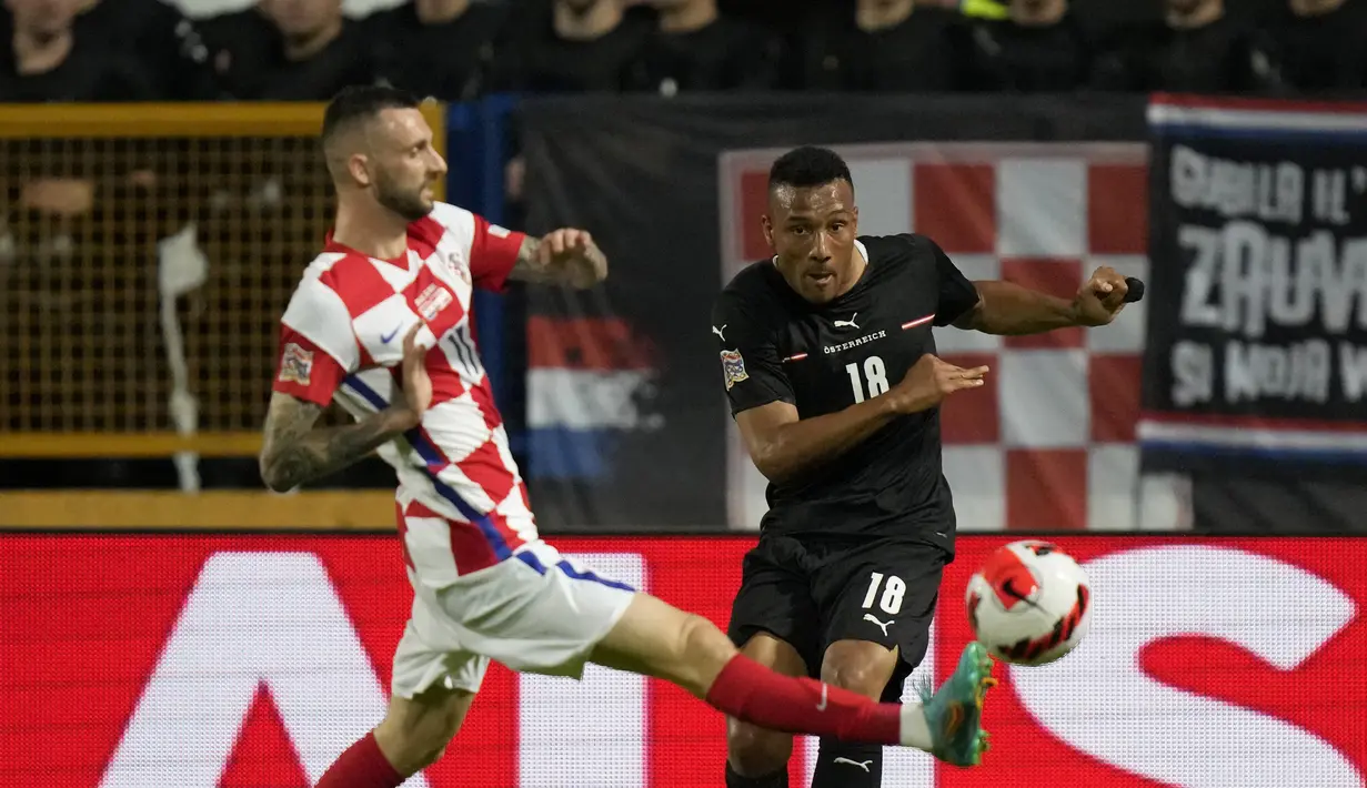 Penyerang timnas Austria Karim Onisiwo berebut bola dengan gelandang Kroasia Marcelo Brozovic pada matchday pertama UEFA Nations League A Grup 1 di Stadion Gradski Vrt, Sabtu (4/6/2022) dinihari WIB. Ralf Rangnick sukses debut dengan mengantarkan Timnas Austria menang telak atas Kroasia dengan skor 3-0. (AP Photo/Darko Bandic)