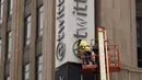 Beberapa jam setelah Elon Musk secara resmi meluncurkan rebranding platform media sosial Twitter dengan logo "X" yang baru, seorang pekerja terlihat mencopot sebagian papan nama di luar kantor pusat perusahaan di pusat kota San Francisco. (AP Photo/Godofredo A. Vásquez)