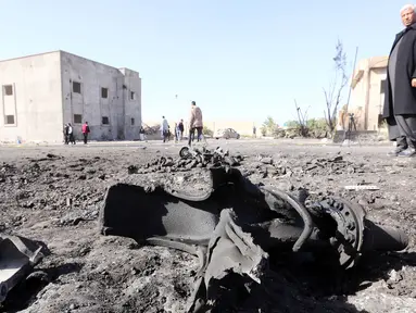 Petugas memeriksa lokasi bom truk yang meledak di sebuah sekolah polisi di kota Zliten, wilayah barat Libya, Kamis (7/1). Belum ada yang mengaku bertanggung jawab terkait serangan bom yang menewaskan sedikitnya 50 orang tersebut. (AFP PHOTO/MAHMUD Turkia)