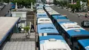 Seorang warga melewati Bus Transjakarta mogok kerja mengantarkan penumpang di Halte Harmoni, Jakarta (12/6). Para supir menuntut penghapusan kontrak yang bertahun-tahun serta meminta pengangkatan karyawan tetap. (Liputan6.com/Gempur M Surya)