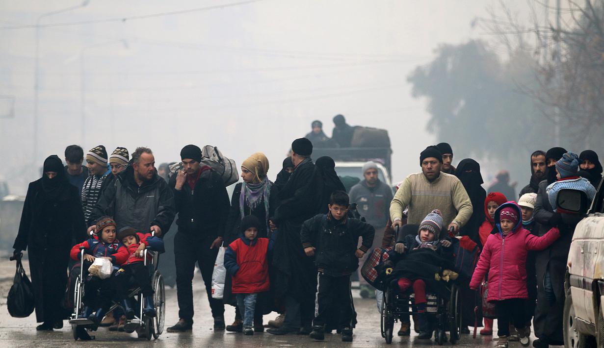 Sejumlah orang melarikan diri dari wilayah yang dikuasai pemberontak, Aleppo, Suriah (13/12). (REUTERS / Abdalrhman Ismail)