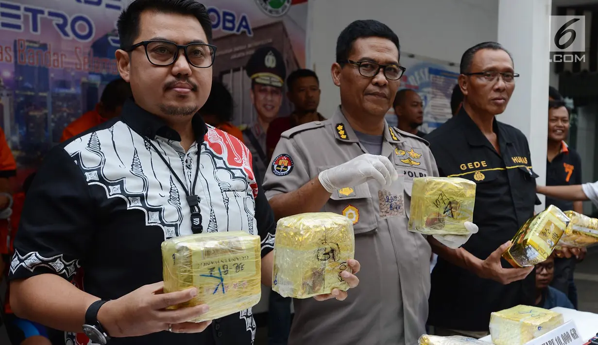 Kabid Humas Polda Metro Jaya Kombes Pol Argo Yuwono (tengah) menunjukkan barang bukti kasus narkoba di Polda Metro Jaya, Jakarta, Jumat (1/3). Subdit II Resnarkoba menangkap lima tersangka dalam kasus ini. (Merdeka.com/ImamBuhori)