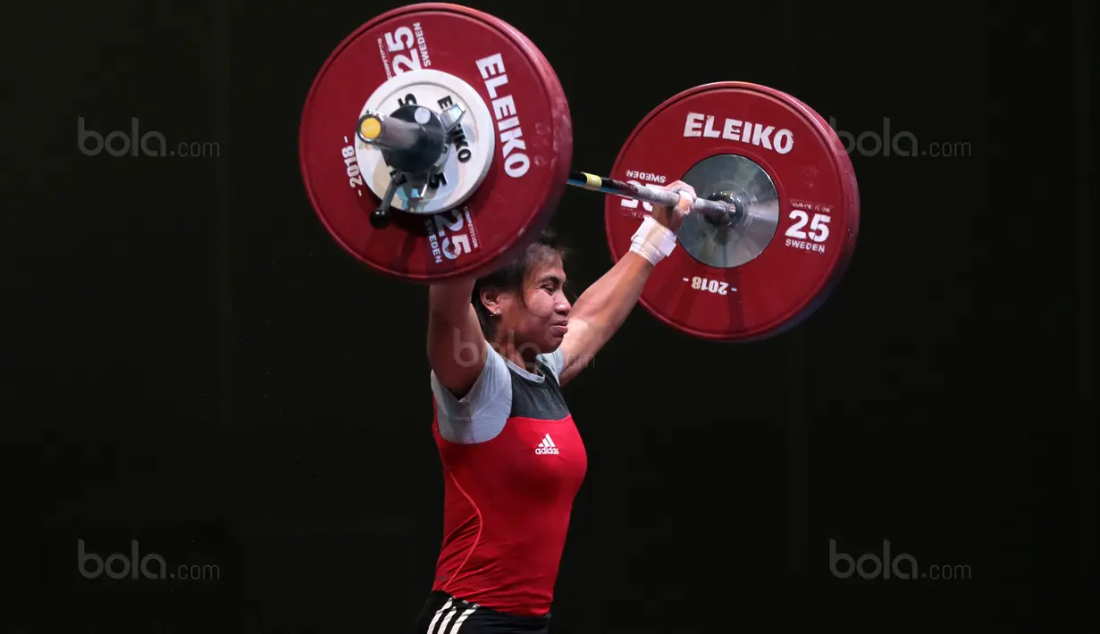 Senyum Sri Wahyuni saat turun pada kelas 48 kg di Hall A Arena PRJ, Jakarta, Rabu (11/2/2018). Sri Wahyuni meraih medali emas dengan total angkatan 187 kg. (Bola.com/Nicklas Hanoatubun)